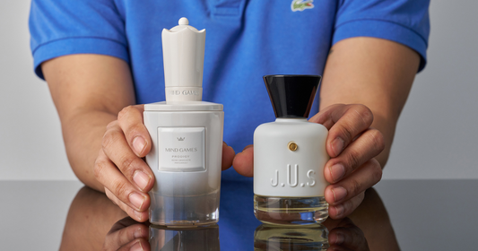 A man in blue shirt holding a bottle of MAISON J.U.S.  SUPERFUSION Eau De Parfum and MIND GAMES  Prodigy Extrait de Parfum.