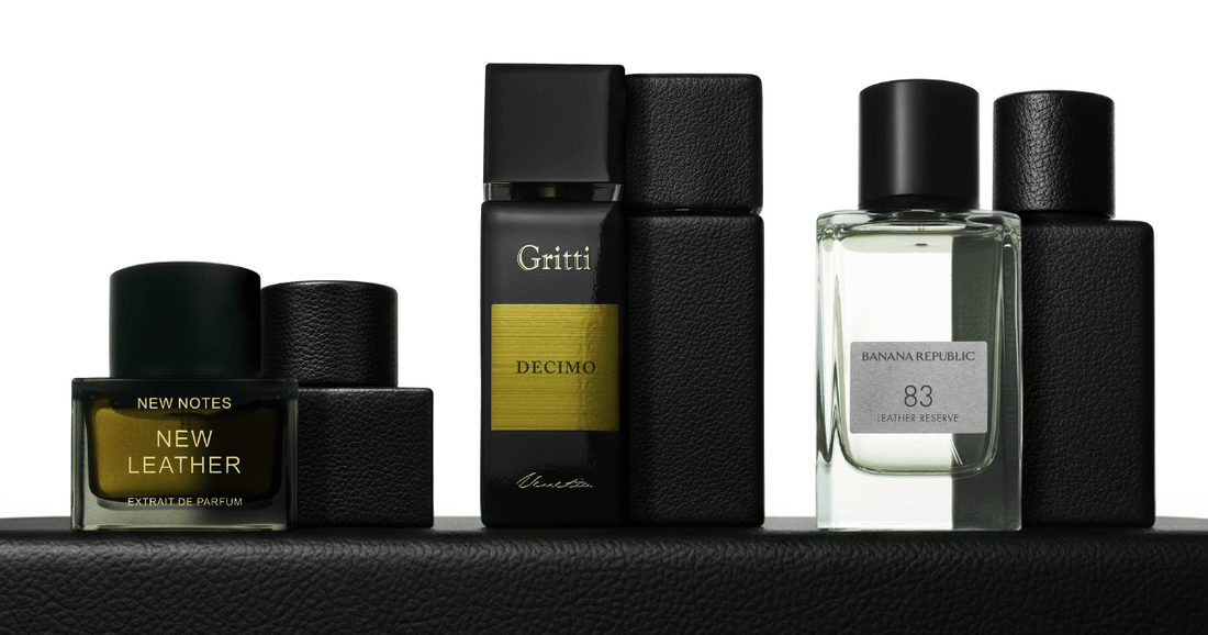 Leather fragrances by Gritti, Banana Republic, and New Notes on a leather table top against a white background.