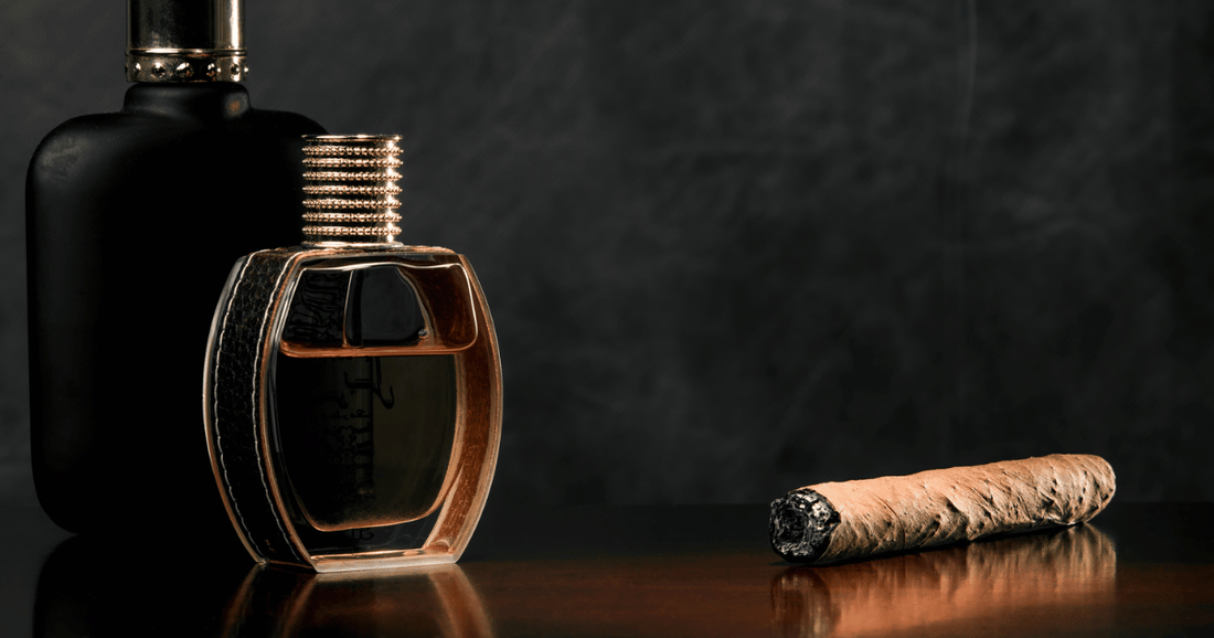 Two bottles of tobacco fragrances next to a cigar on a wood table.