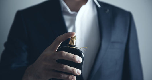 A man in business suit spraying on a confidence boosting fragrance.