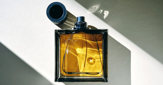 A musk fragrance against a white background with shadows in the corner.