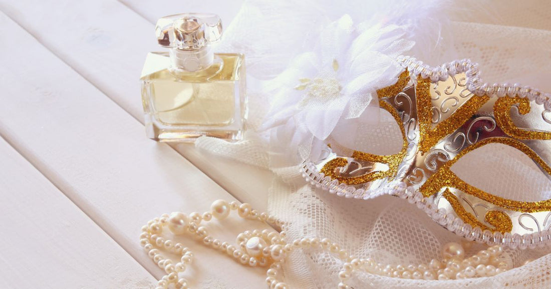 An Italian carnavial mask next to an Italian perfume bottle.